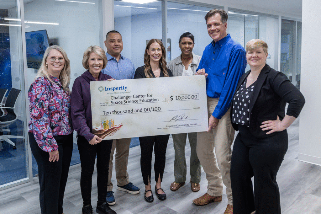 Six people, three men and three women, smiling and holding a large ceremonial check for $10,000 from Insperity to the Challenger Center for Space Science Education.
