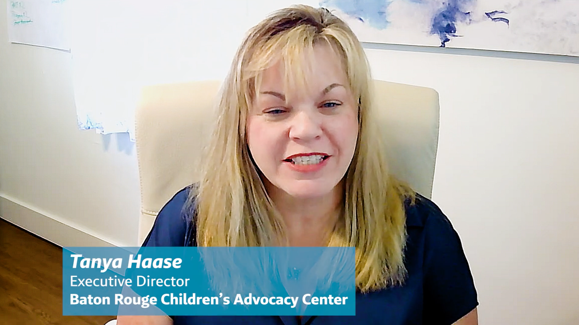 Tanya Haase, Executive Director of Baton Rouge Children's Advocacy Center, smiling and speaking, with her name and title displayed on a blue banner.