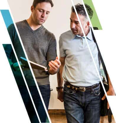 Two men, one holding a tablet, are engaged in a discussion. The image is overlaid with diagonal colored and white stripes.