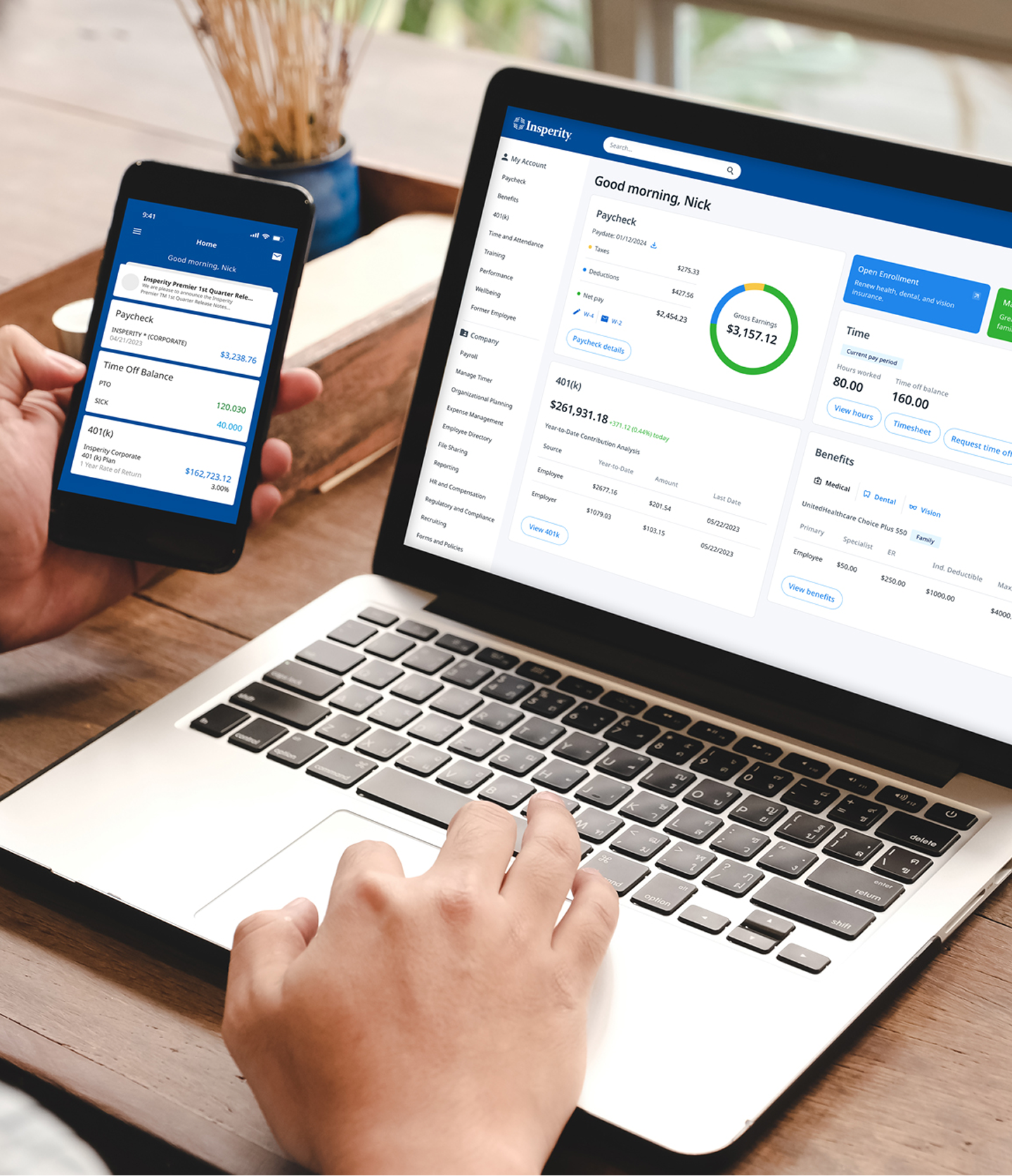 A person using a laptop and a smartphone simultaneously, both displaying the Insperity HR and payroll management application.